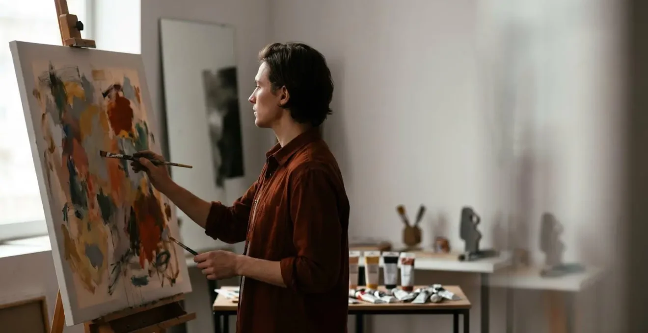 An artist contemplating their reflection while creating a traditional self-portrait in a sunlit studio